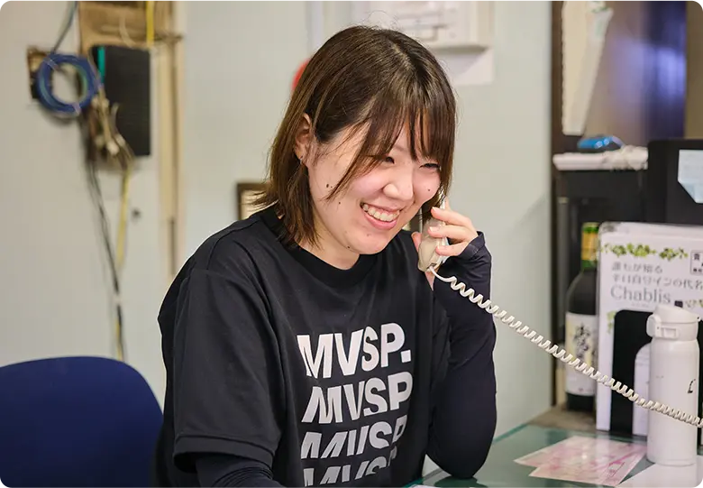 笑顔で電話対応する業務部スタッフの様子