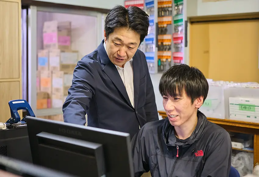 スタッフ２名がパソコンを見て相談する様子